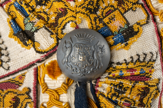 Detail kabátu kočího rodu Clam Gallasů, hedvábná porta a knoflík s rodovým znakem, konec 19.století, SZ Frýdlant